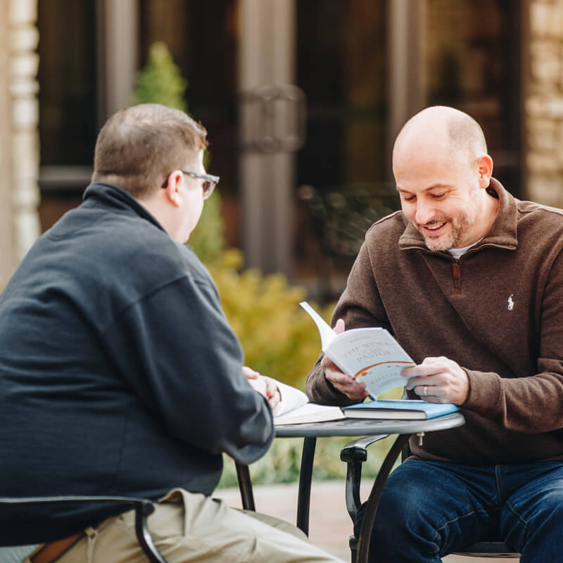 two men outside at a table