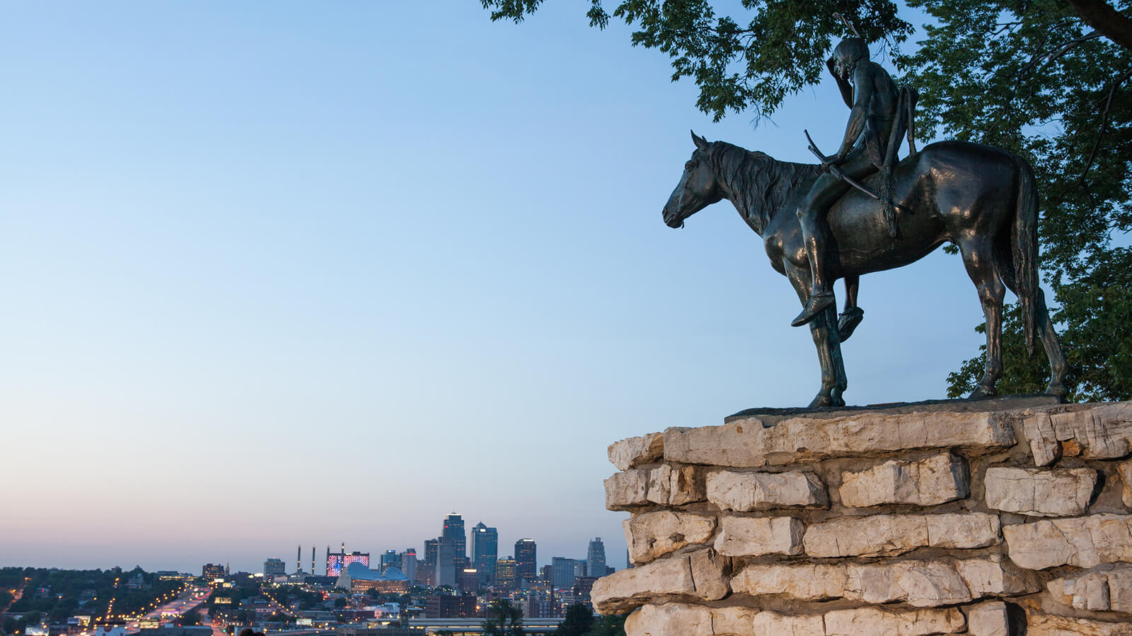 metal sculputre of man on horse overlooking the city