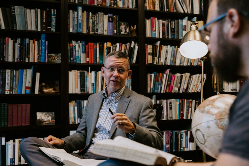 Dr. Jason DeRouchie mentors one of his students in his office